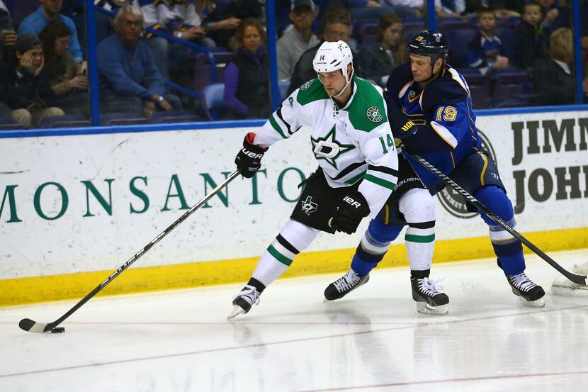 ST. LOUIS, MO - MARCH 11: Jamie Benn #14 of the Dallas Stars fends off Jay Bouwmeester #19...
