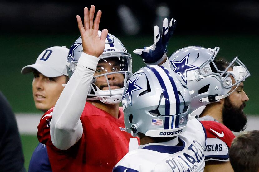 Dallas Cowboys quarterback Dak Prescott (4) high-fives running back Tony Pollard (20) during...