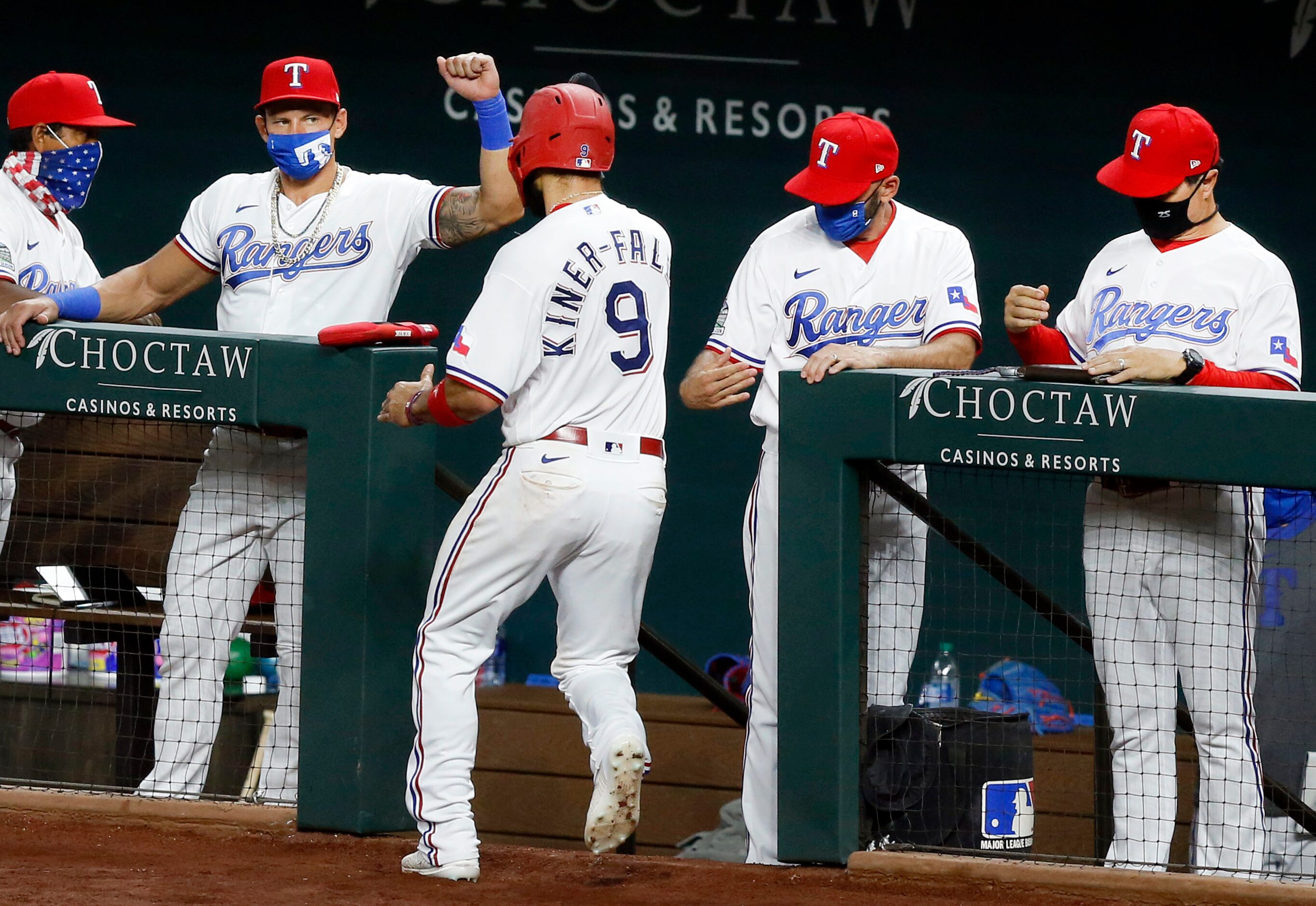 Texas Rangers Isiah Kiner-Falefa (9) is congratulated by the coaching staff and players...