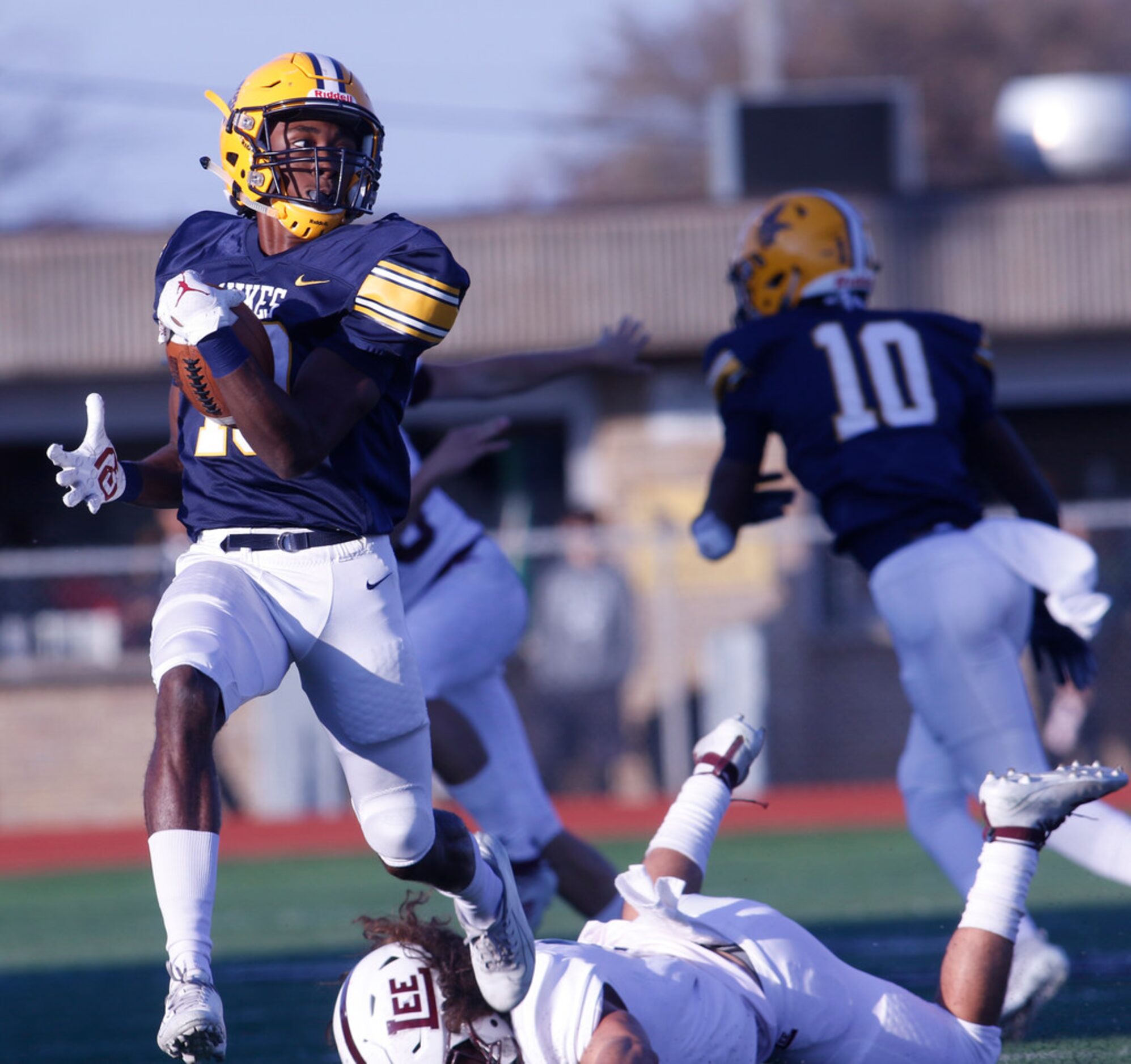 Arlington Lamar receiver Trevor West (19) leaps from the attempted tackle of Midland Lee...