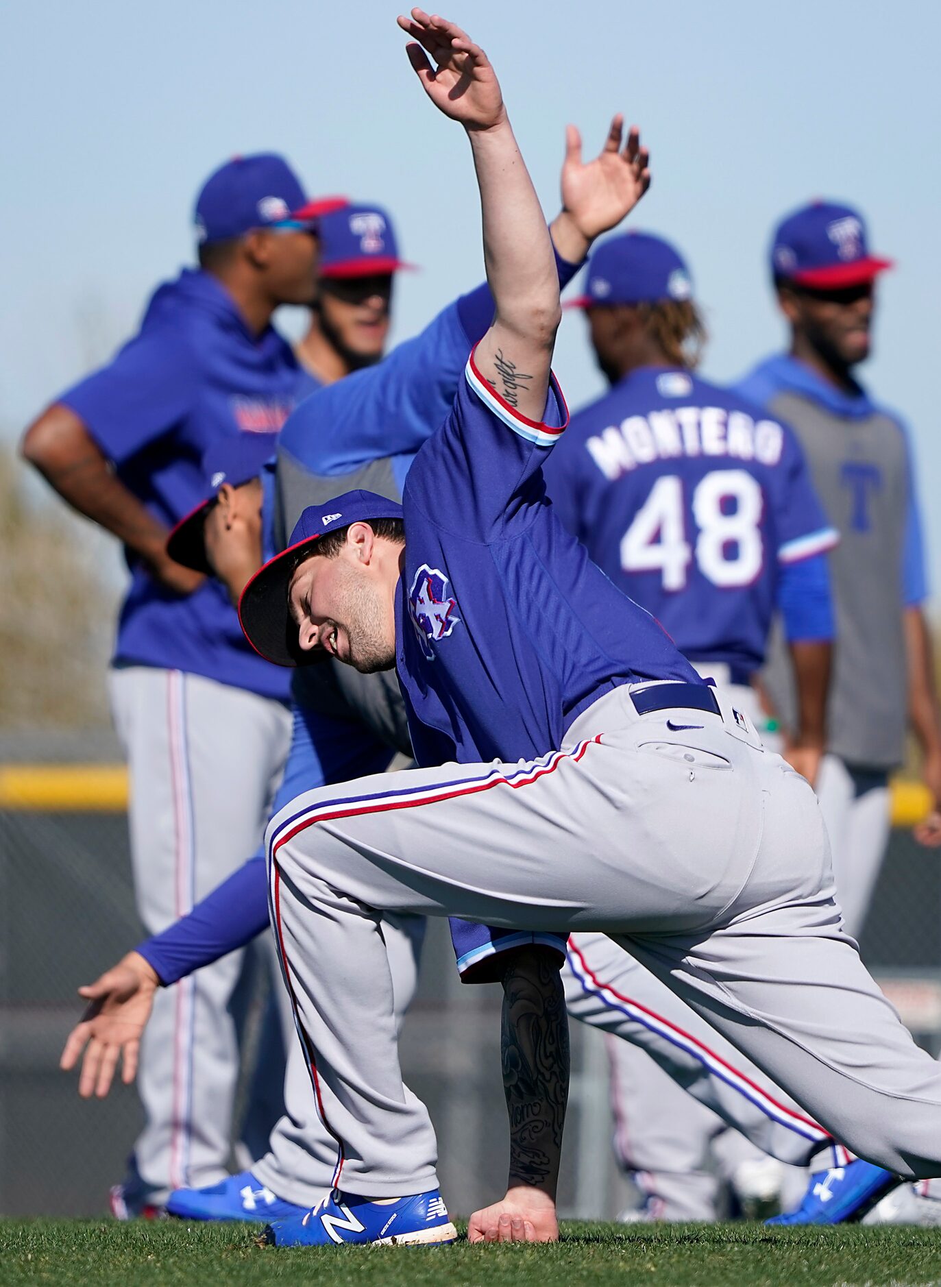 Texas Rangers pitcher Joe Palumbo stretches with teammates during a spring training workout...