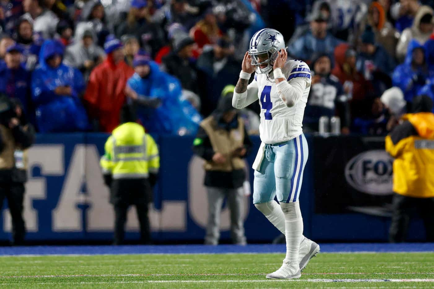 Dallas Cowboys quarterback Dak Prescott (4) takes his helmet off as he walks off the field...