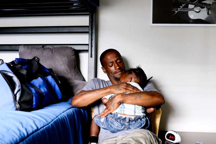 Joshua Miller rocks his son Jordan, 2, to sleep at The Family Place's men's shelter in...