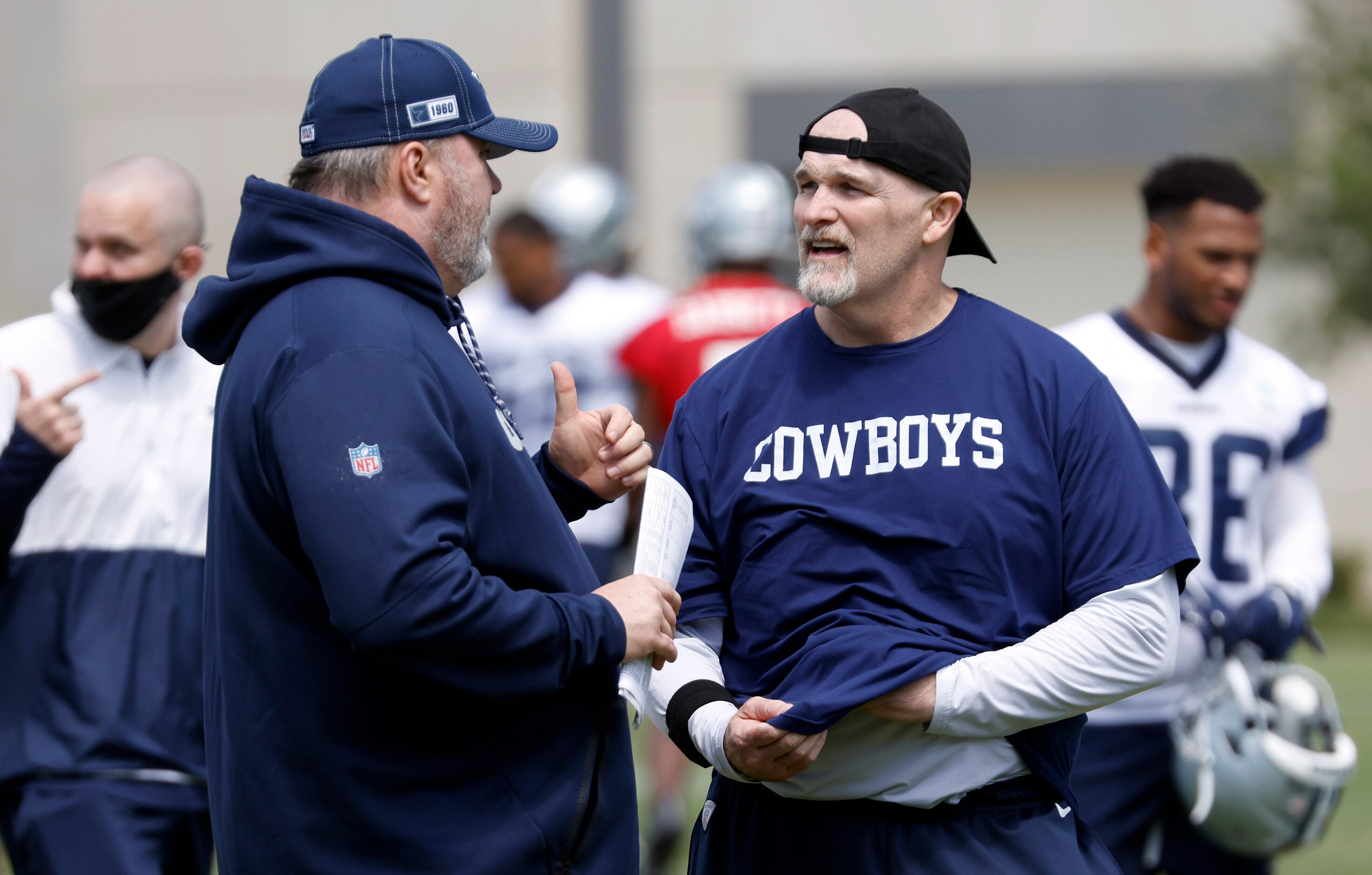 Dallas Cowboys head coach Mike McCarthy (left) visits with defensive coordinator Dan Quinn...