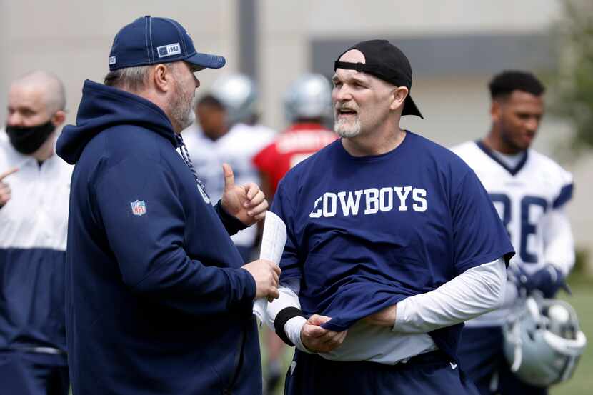 Dallas Cowboys head coach Mike McCarthy (left) visits with defensive coordinator Dan Quinn...