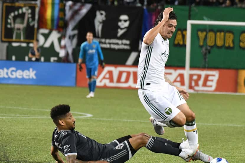 Portland Timbers' Sebastian Blanco, right, tries to control the ball against Vancouver...