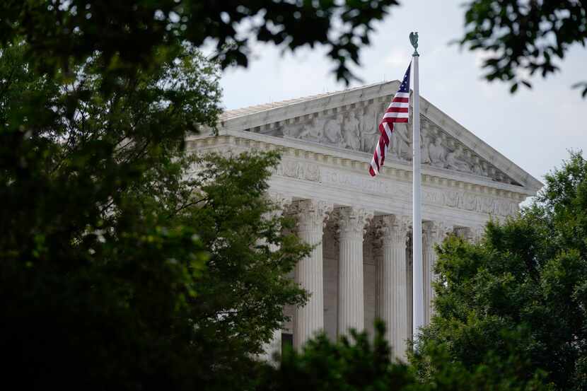 FILE - An American flag waves in front of the U.S. Supreme Court building, Monday, June 27,...