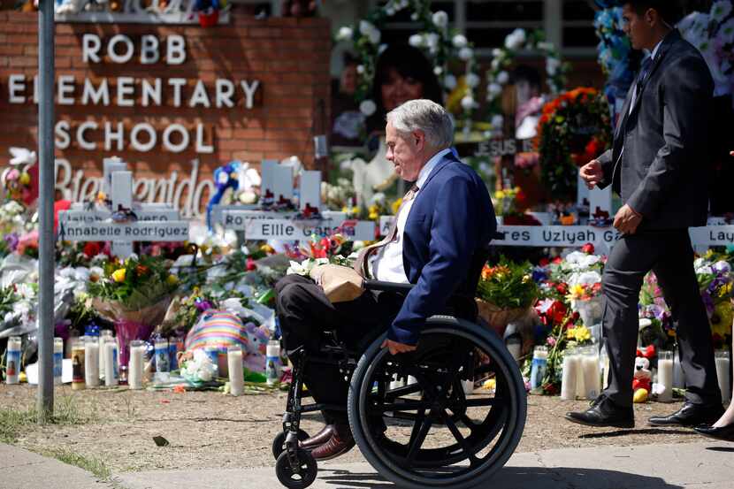 FILE - Texas Gov. Greg Abbott passes in front of a memorial outside Robb Elementary School...