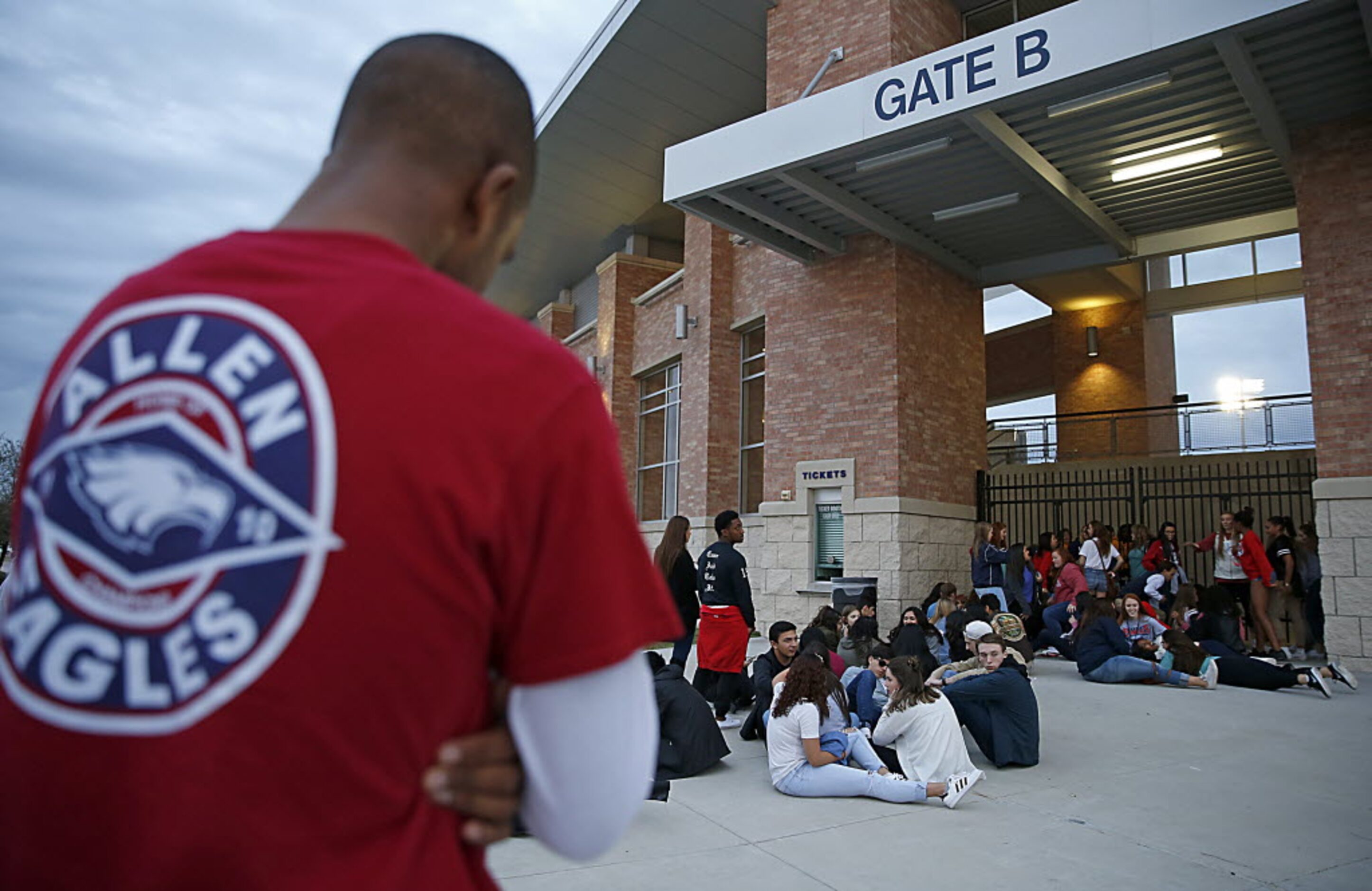 Allen football fans including Ethan Constantine, 18, in a red shirt, left, wait in line to...