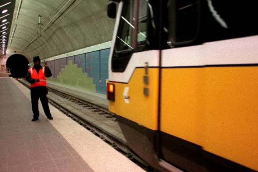 A DART worker flagged a light rail train through the tunnel at Cityplace Station in 2000.