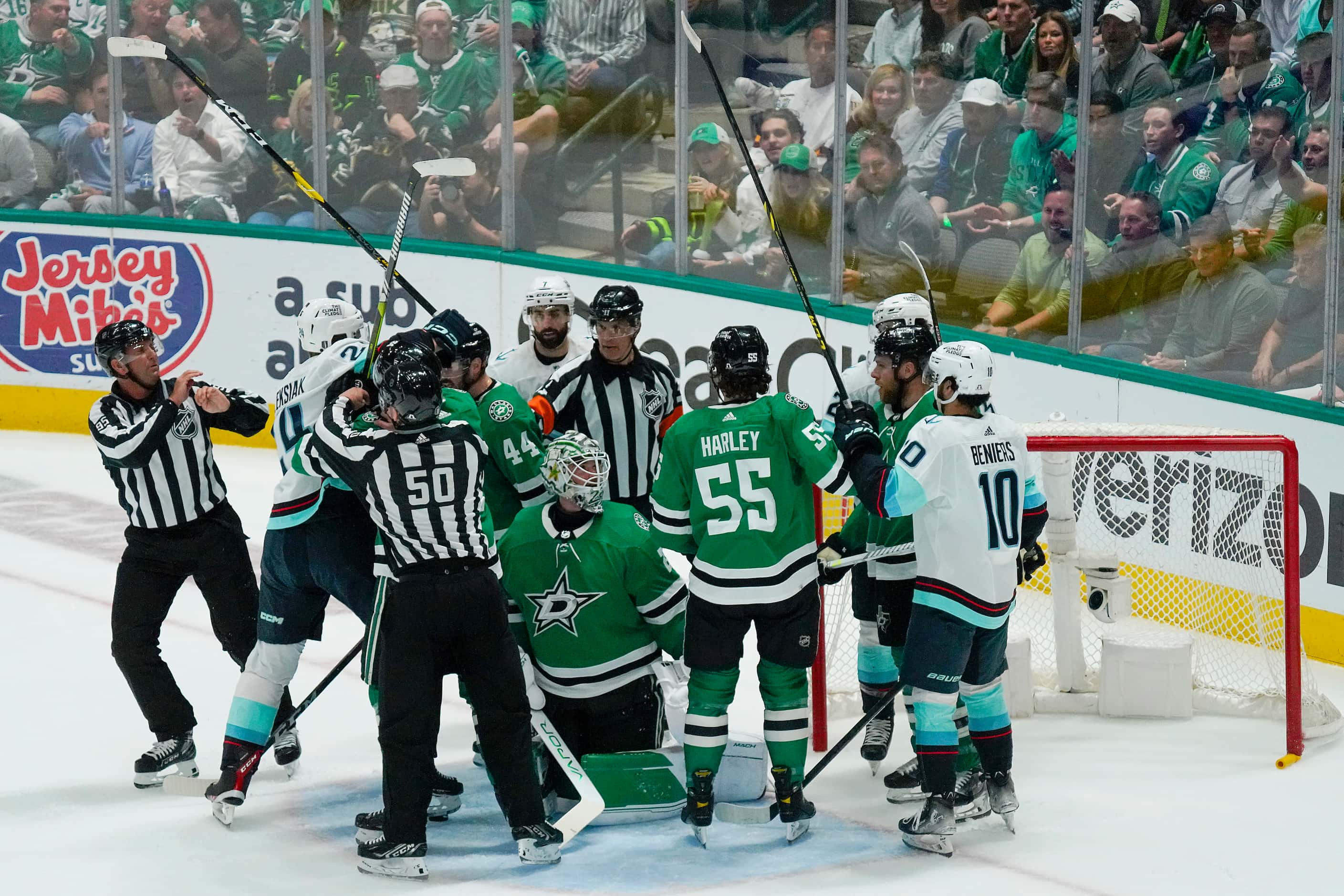 Officials try to break up players around Dallas Stars goaltender Jake Oettinger (29) during...