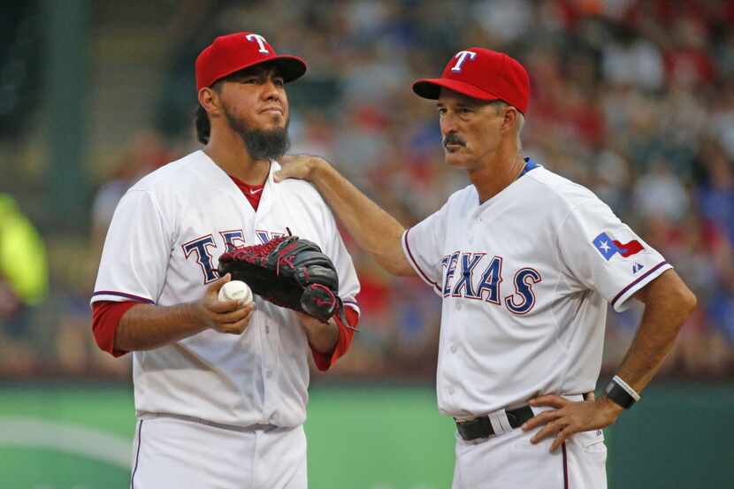 Texas Rangers starting pitcher Yovani Gallardo (49) is visited by pitching coach Mike Maddux...