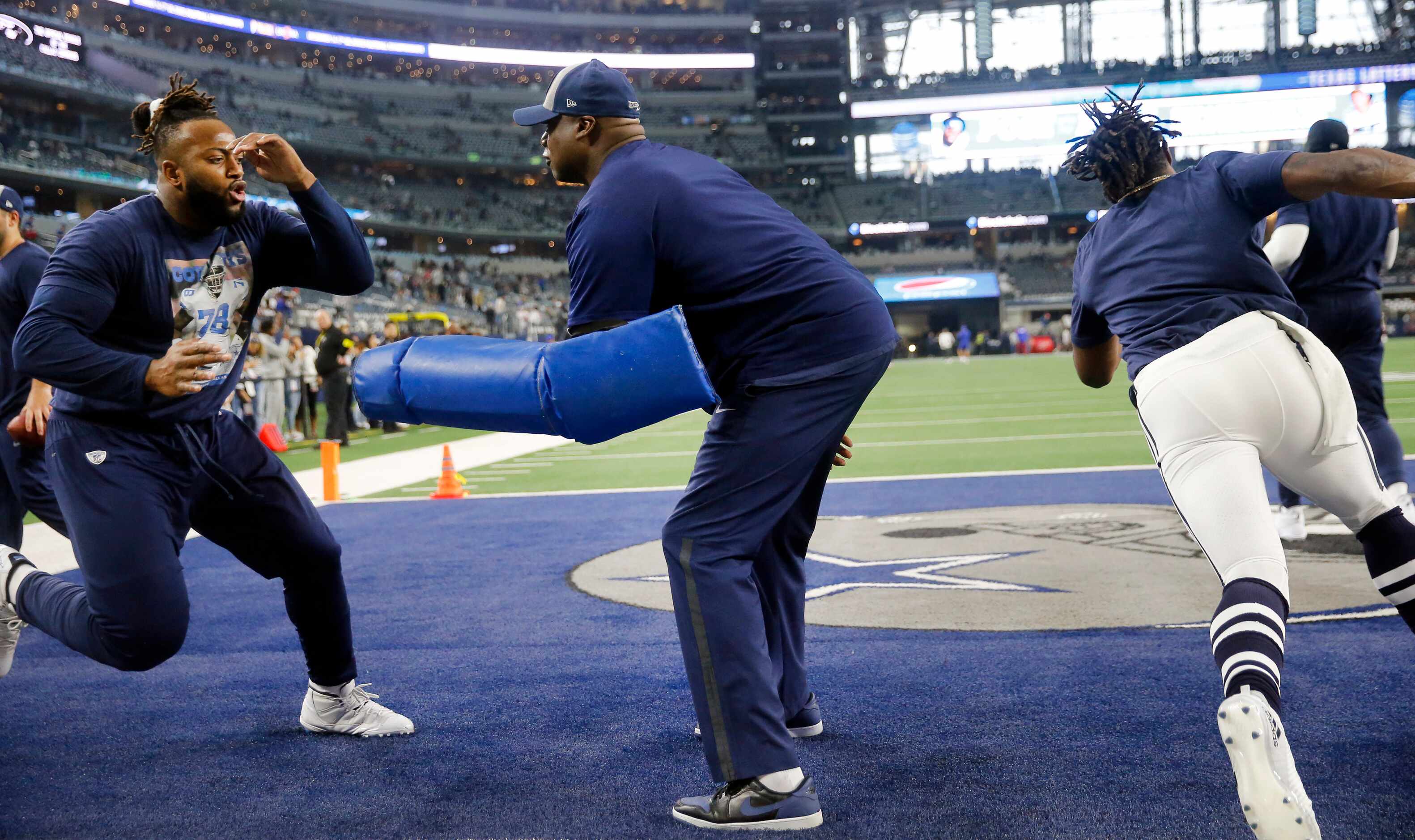 Dallas Cowboys assistant defensive line coach Leon Lett (center) works with players during...