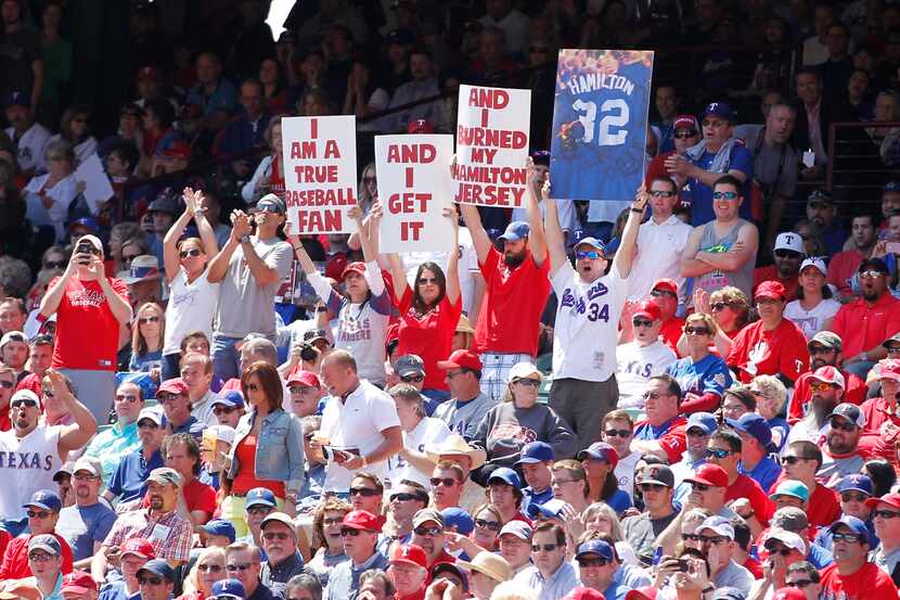 Apr 5, 2013; Arlington, TX, USA; Texas Rangers fans hold up signs during the first at bat of...