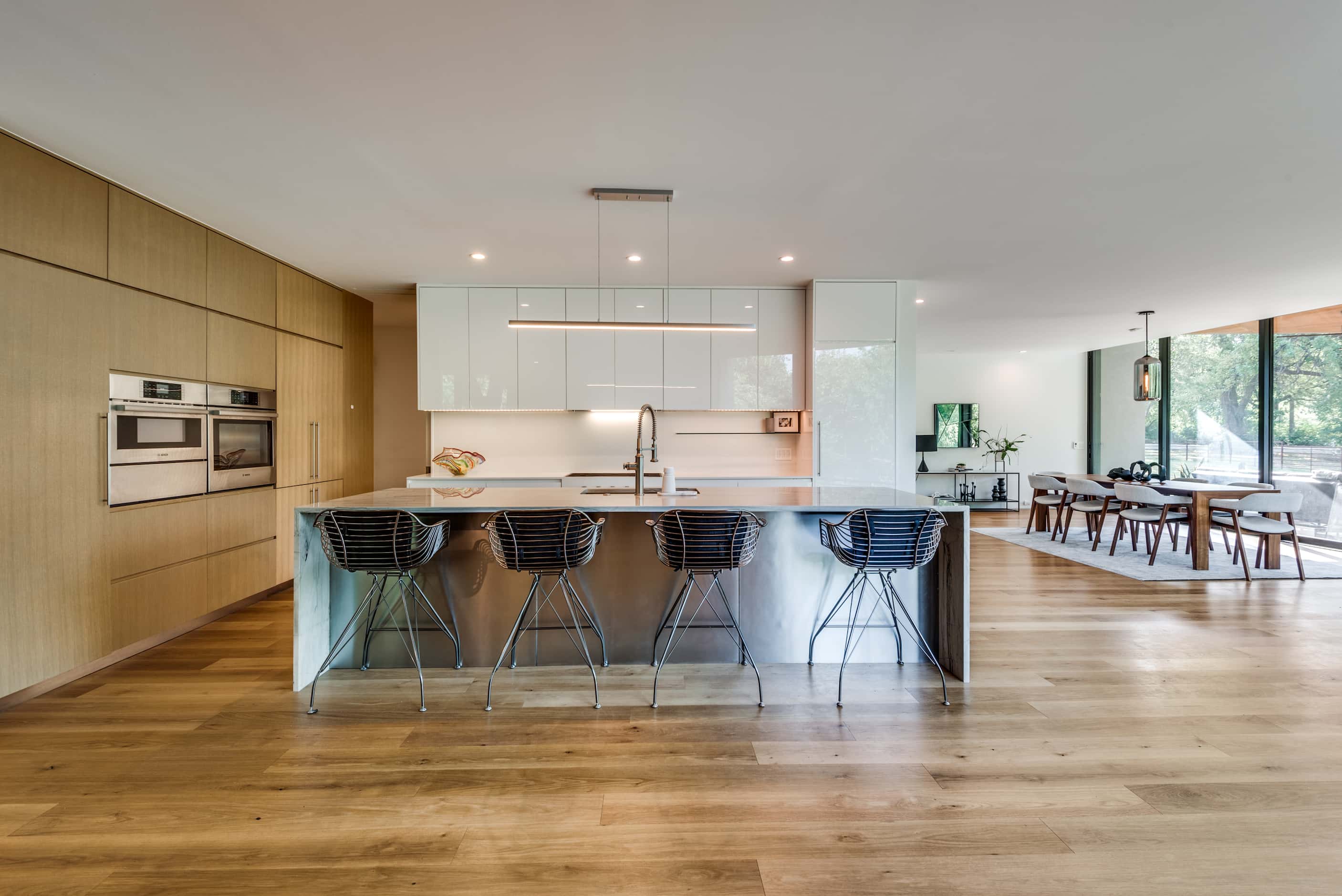 Interior of contemporary home, open-concept kitchen, countertop seating, wood cabinets