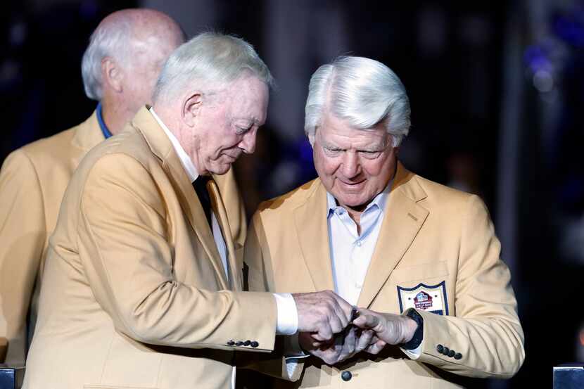 El dueño de los Cowboys de Dallas, Jerry Jones (izq), le pone el anillo del Salón de la Fama...