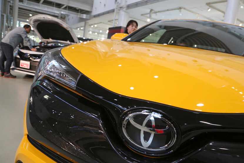 In this Nov. 13, 2017, photo, visitors take a look at Toyota cars at the automaker's...