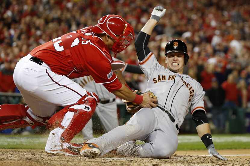 Washington Nationals catcher Wilson Ramos (40) tags out San Francisco Giants' Buster Posey...