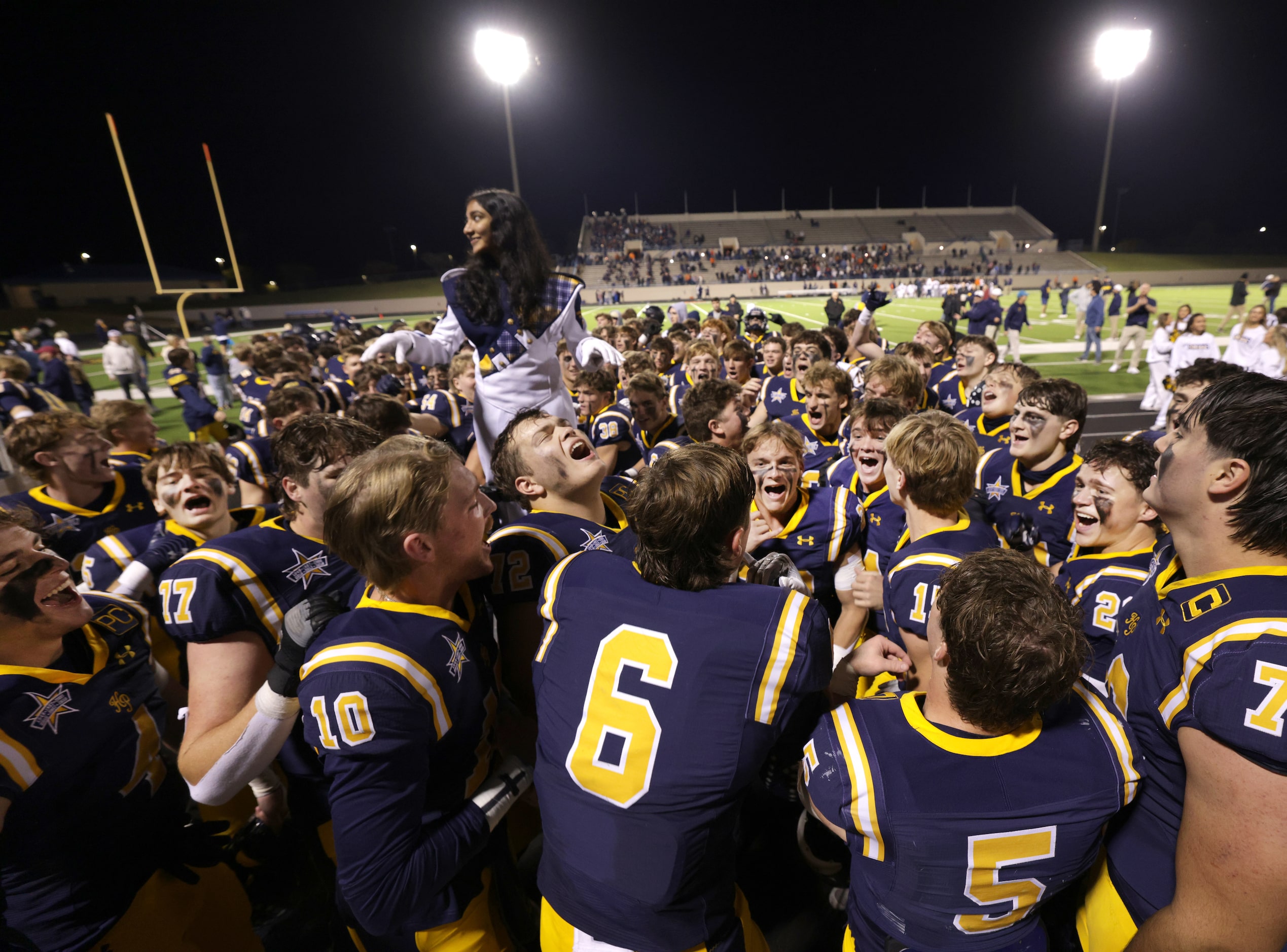 Highland Park High School players celebrate after winning a football playoff game against...