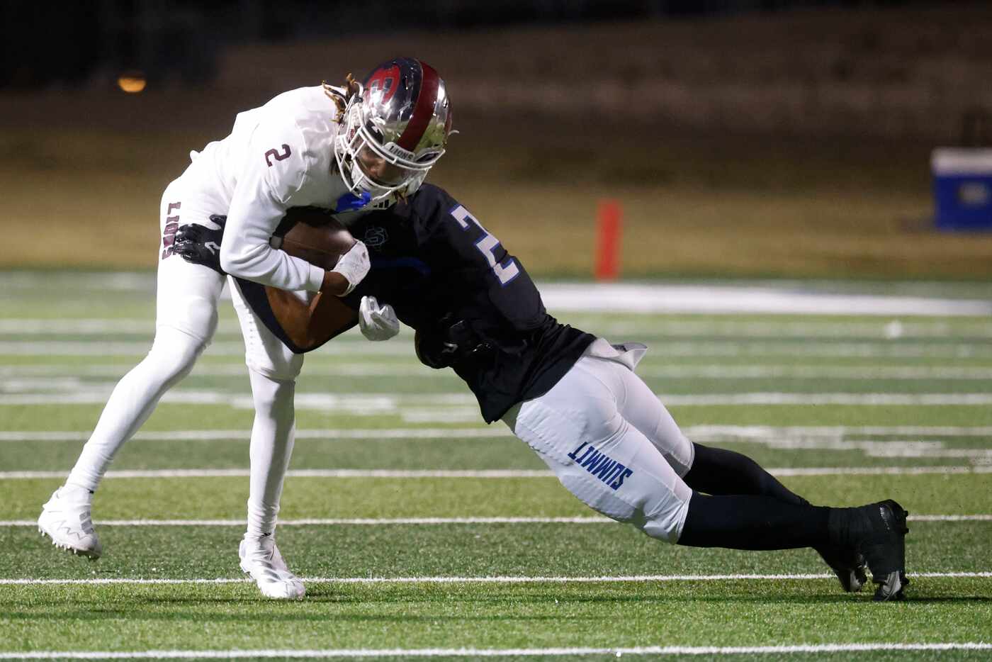 Ennis High School’s Lamarion McGowan (left) gets tackled by Mansfield Summit High’s Joseph...