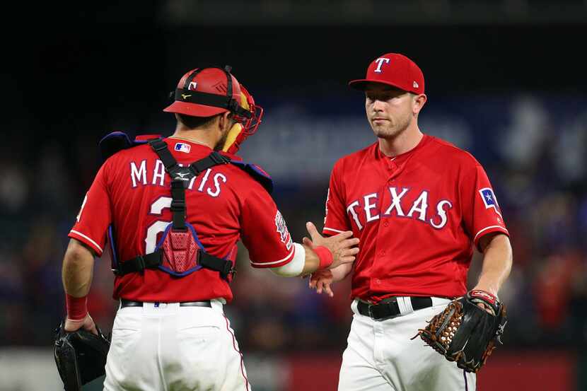 ARLINGTON, TEXAS - JUNE 08: Jeff Mathis #2 of the Texas Rangers congratulates Adrian Sampson...