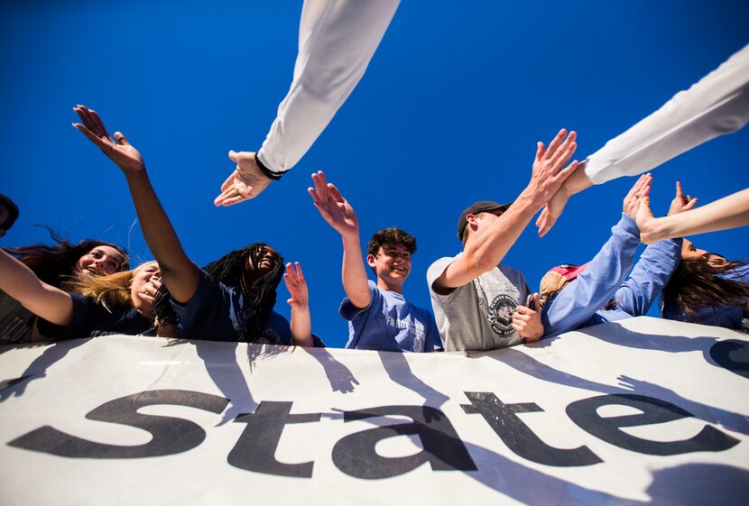 Flower Mound fans get high-fives from their soccer players after a 3-2 win in a UIL 6A boys...