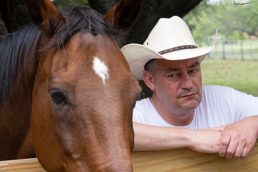 Neil Foreman looks over at Benji, his rescued racehorse, at his home in unincorporated...