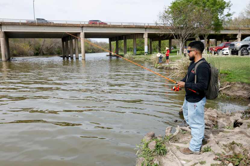Christian Alemán of Forney fishes along White Rock Creek at White Rock Lake on March 20 in...