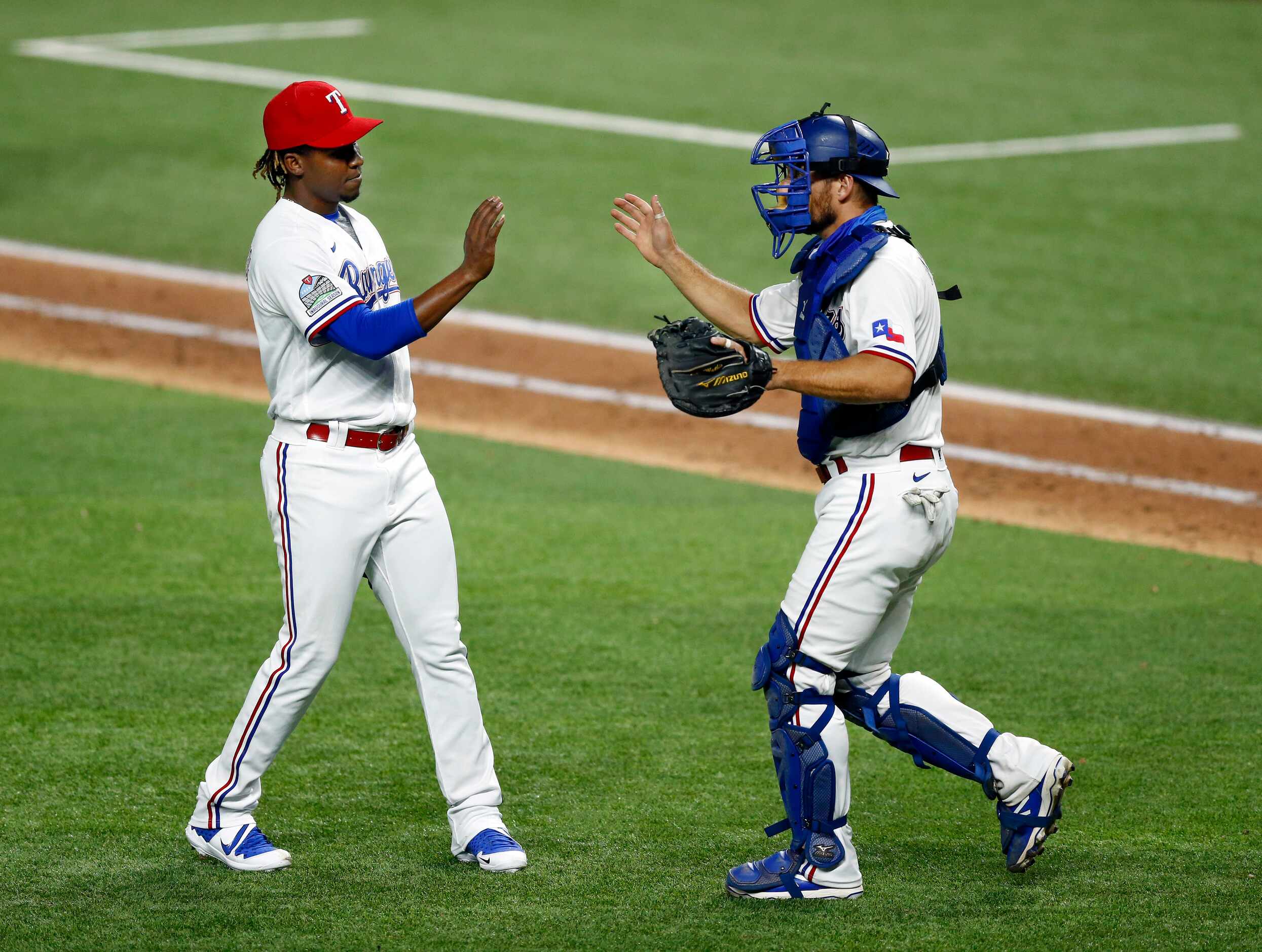 Texas Rangers relief pitcher Rafael Montero (left) is congratulated on his save by catcher...