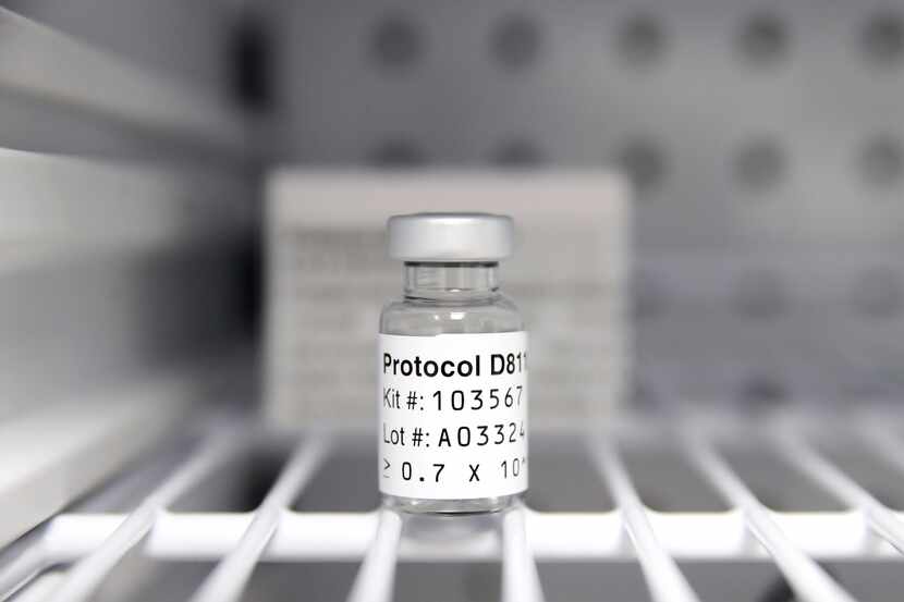 A sterile vial of AstraZeneca Phase III trial COVID vaccine sits in a refrigerator at the...