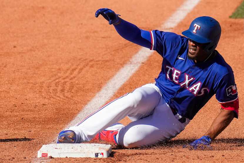 Texas Rangers outfielder Elier Hernández is safe at third base with a triple during the...