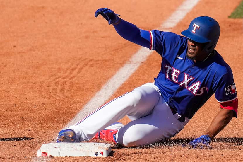 Texas Rangers outfielder Elier Hernández is safe at third base with a triple during the...