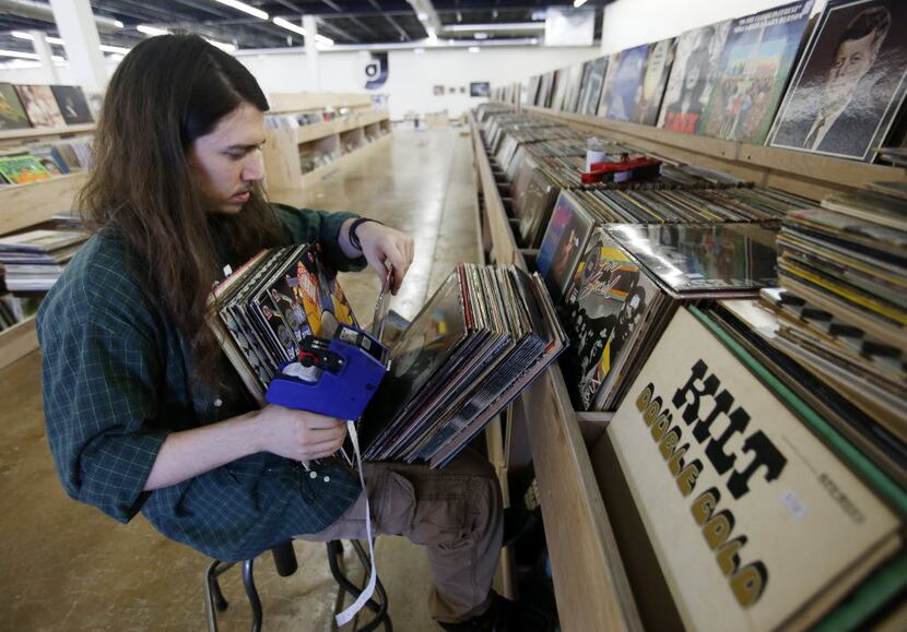 Ben Hixon, works on putting price tags on records in preparation for the opening at Josey...