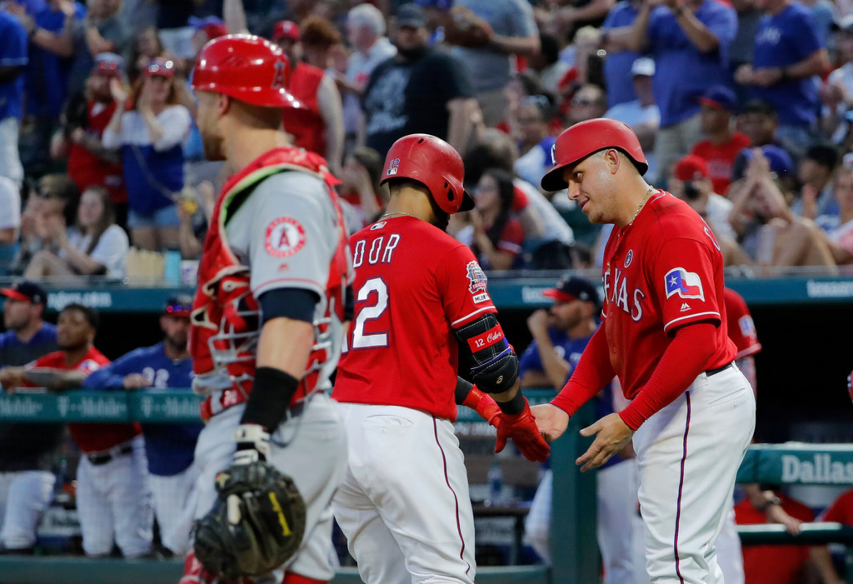 Los Angeles Angels' Jonathan Lucroy stand by the plate as Texas Rangers' Rougned Odor and...