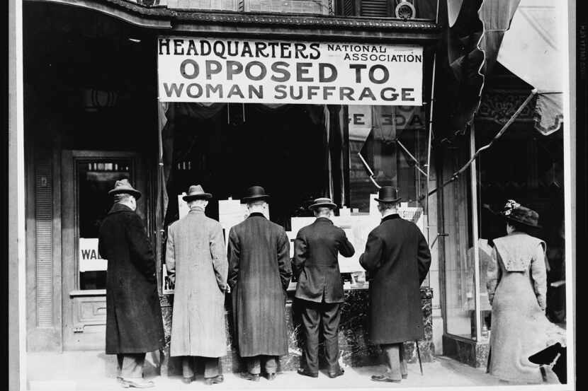 Men look at material posted in the window of the National Anti-Suffrage Association...