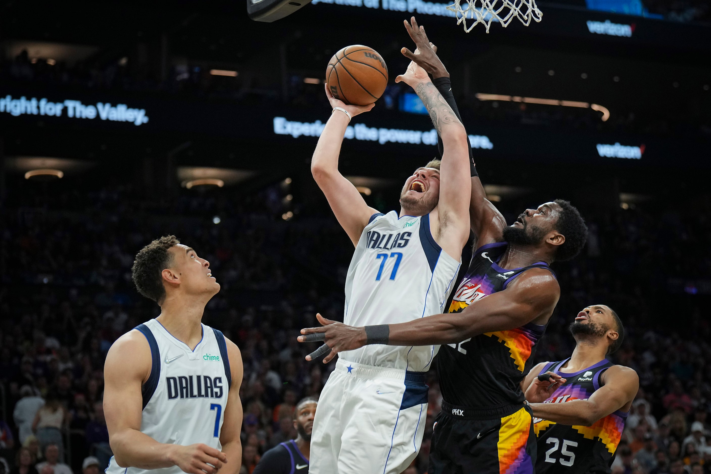 Dallas Mavericks guard Luka Doncic (77) is fouled by Phoenix Suns center Deandre Ayton (22)...