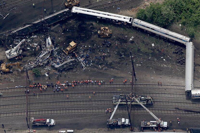  Investigators and first responders work near the wreckage of Amtrak Northeast Regional...