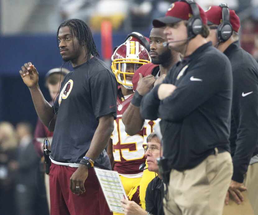 Washington quarterback Robert Griffin III watches the game from the sidelines during the...