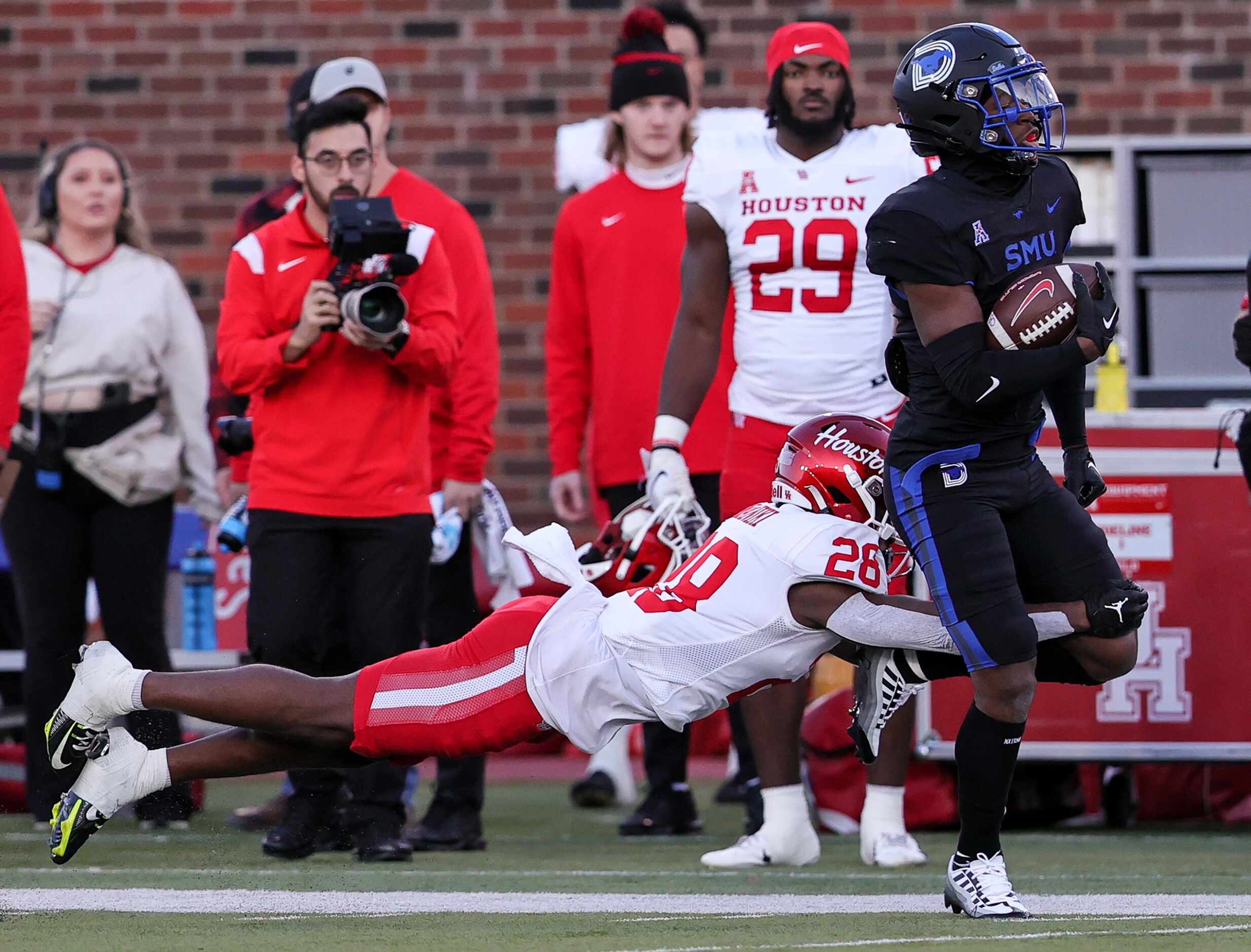 SMU kickoff returner Bryan Massey (right) returns a kickoff 53 yards as he is brought down...