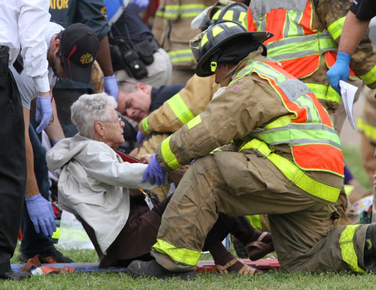 Rescue personnel treat passengers from a charter bus that was hit by a CSX train. (John...