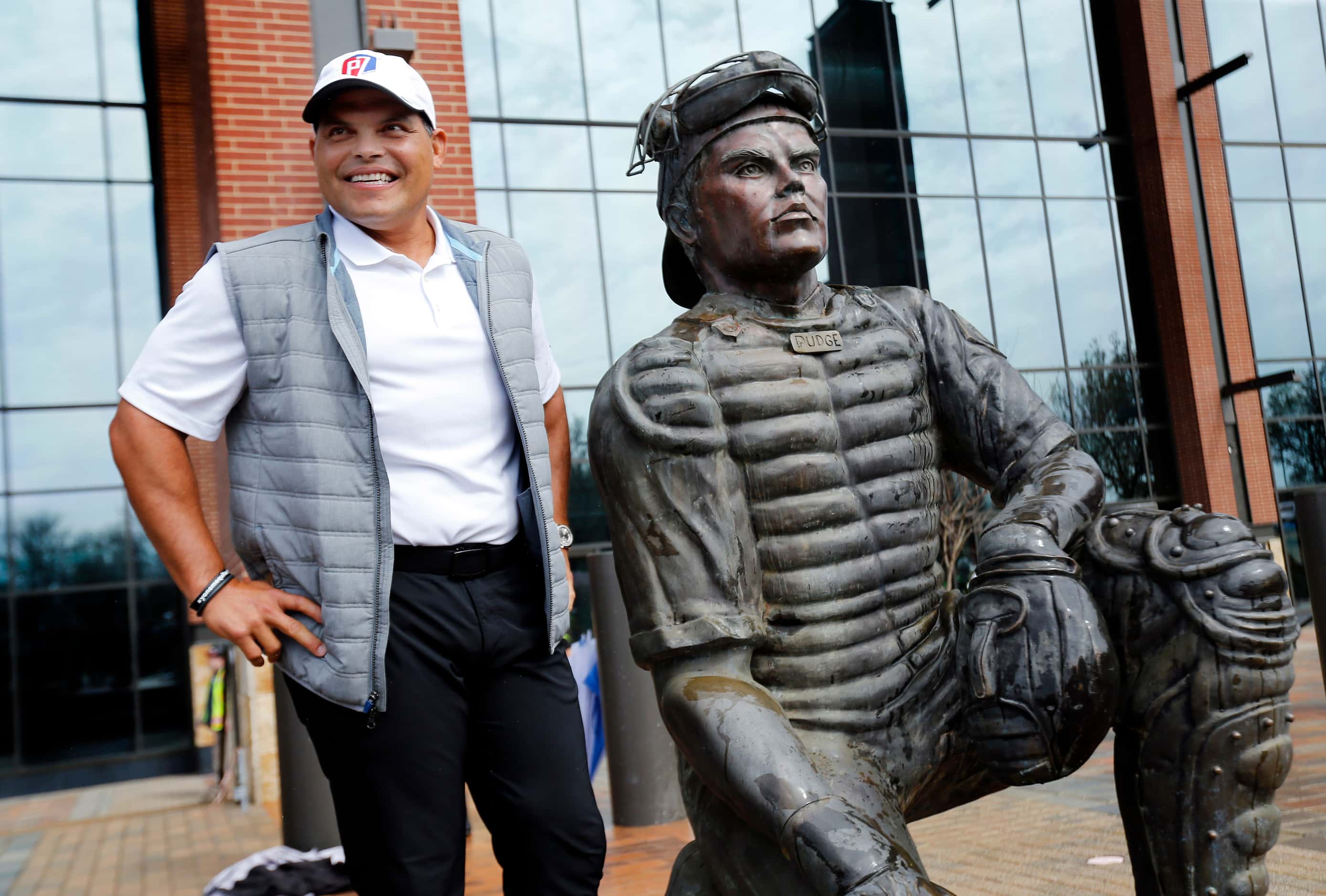 Former Texas Rangers catcher Ivan 'Pudge' Rodriguez poses with his larger than life statue...