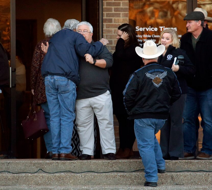 Senior minister Britt Farmer (left, facing camera), shown greeting people before a vigil at...