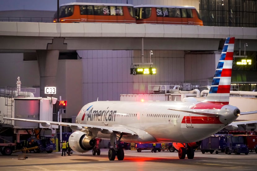 American Airlines planes are seen at the gates of Terminal C at the Skylink train passes...