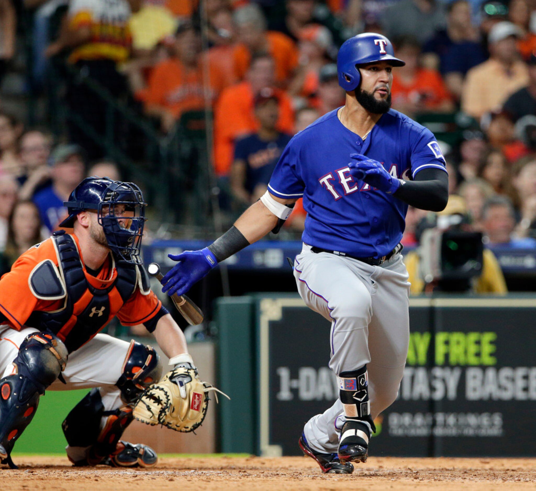 Texas Rangers' Nomar Mazara, right, watches his line-drive double in front of Houston Astros...