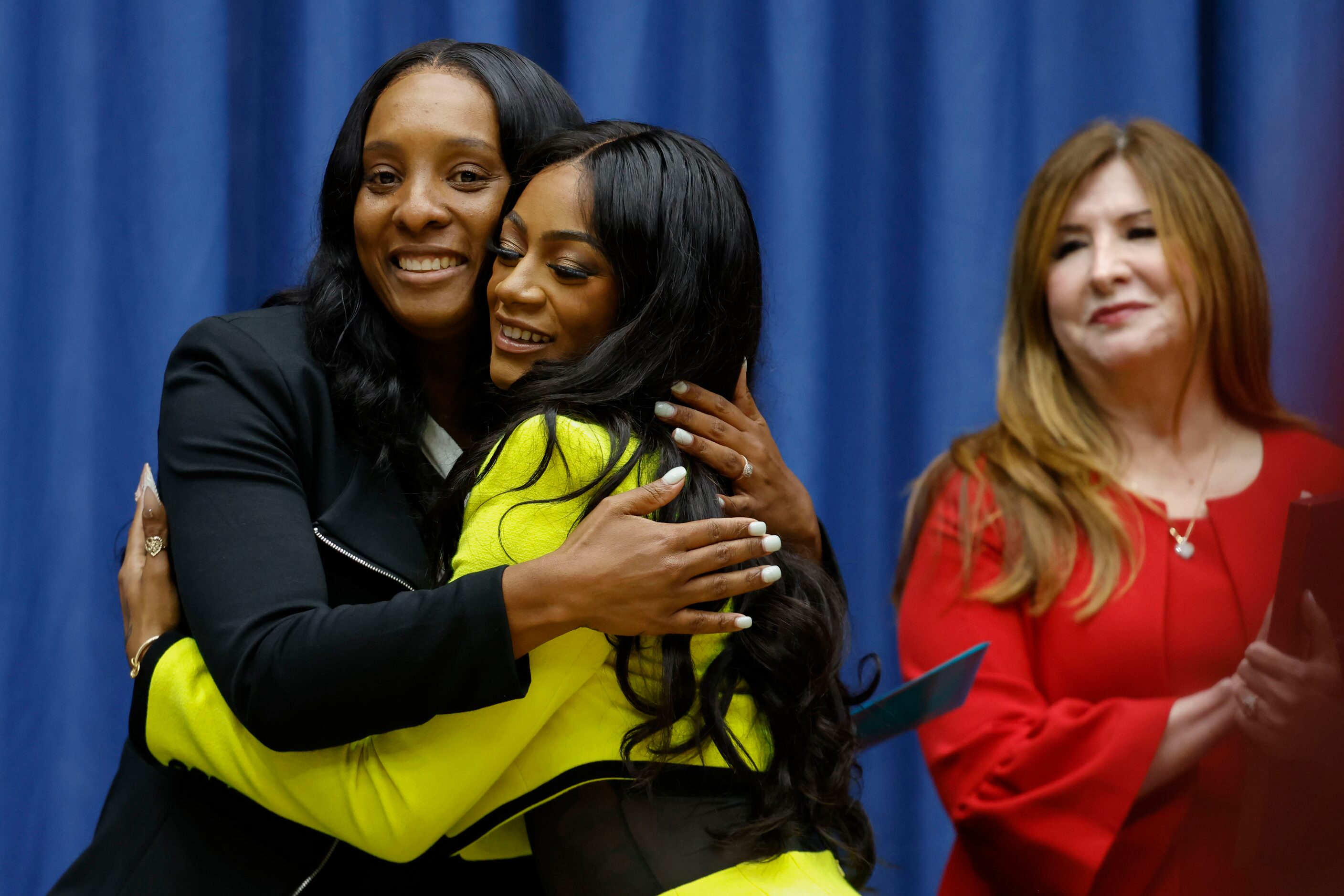 David W. Carter High School’s track and field coach, Lauren Cross (left), embraces 100...