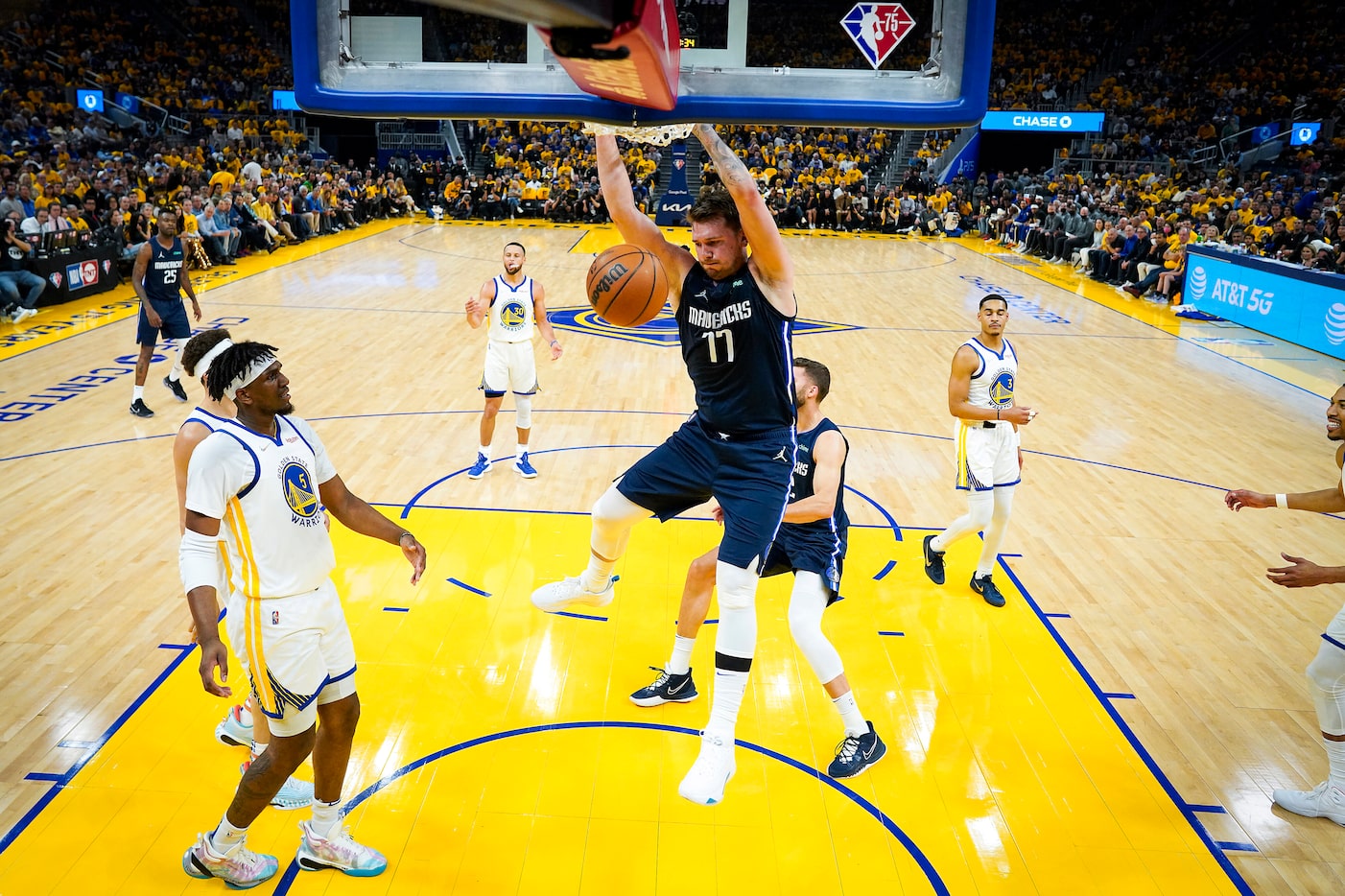 Dallas Mavericks guard Luka Doncic (77) dunks the ball past Golden State Warriors center...