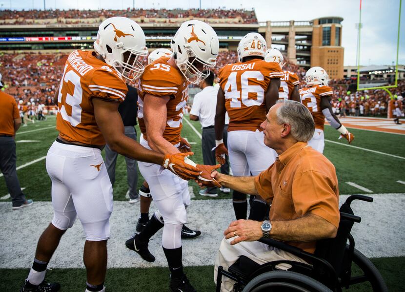 Governor Greg Abbott greets Texas Longhorns players before an NCAA football game between the...