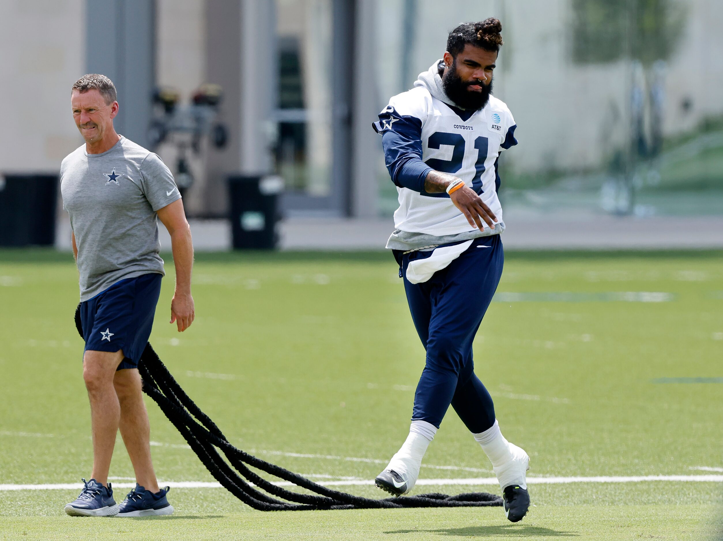 Dallas Cowboys running back Ezekiel Elliott (21) stretches before training camp practice at...