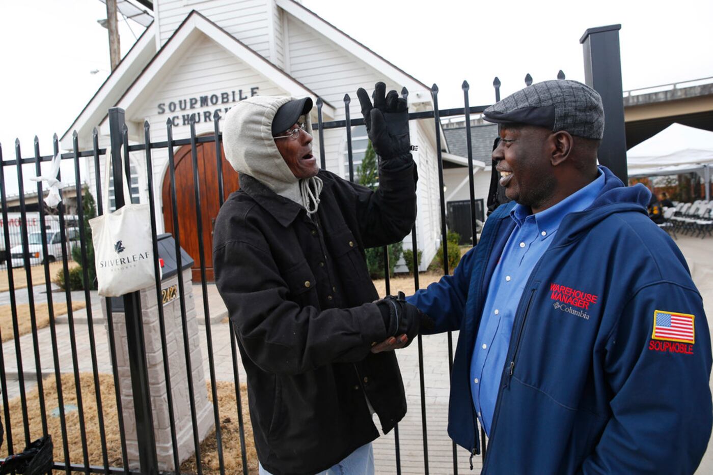 Willie Pearson (left) was greeted by Harvor Davis, church manager, as homeless people lined...
