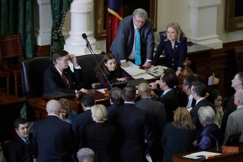 Senators gather around Lt. Gov. Dan Patrick, left, during a point of order as the Texas...